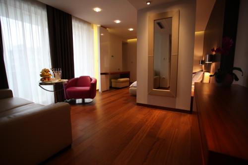a living room with a couch and a red chair at Hotel IN in Međugorje