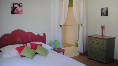 a bedroom with a bed with a red headboard and green pillows at Domaine de Flo ADULT a partir de 16 ans in Saint-Jean-de-la-Blaquière