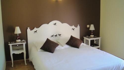 a bedroom with a large white bed with two tables at Domaine de Flo ADULT a partir de 16 ans in Saint-Jean-de-la-Blaquière