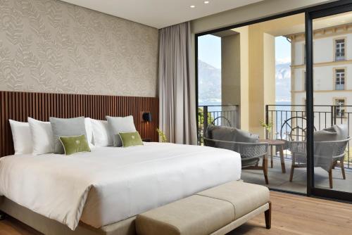 a bedroom with a large bed and a balcony at Grand Hotel Victoria concept & spa, by R Collection Hotels in Menaggio