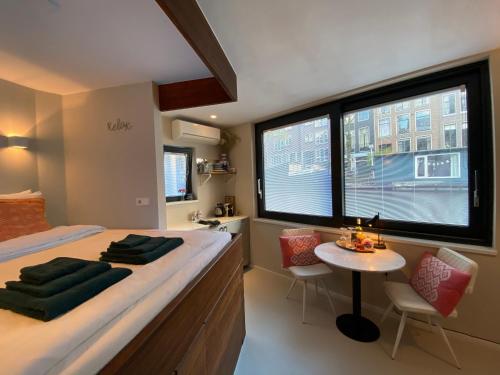 sypialnia z łóżkiem i stołem z krzesłami w obiekcie Houseboat Sophia w Amsterdamie