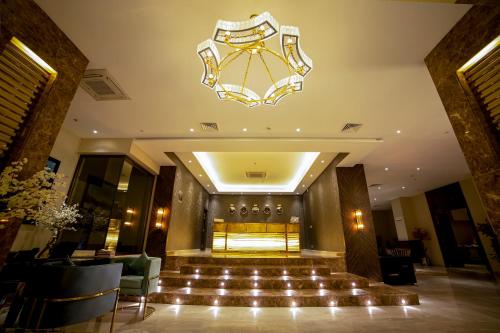 a hotel lobby with a chandelier and a staircase at Best Western Premier Hotel Gulberg Lahore in Lahore
