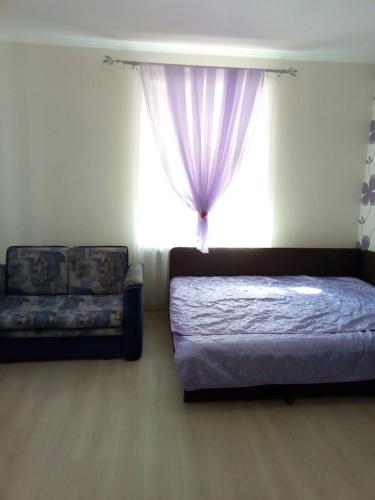 ゼレノグラーツクにあるApartment u bashniのベッドルーム1室(ベッド1台、ソファ、窓付)