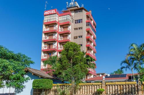 un edificio de hotel con un árbol delante de él en Hotel das Rosas en Sapiranga