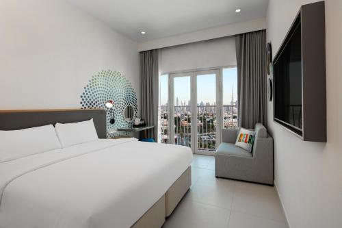 a bedroom with a large bed and a large window at Rove La Mer Beach, Jumeirah in Dubai