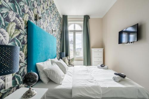 una camera da letto con un grande letto bianco con testiera blu di Nador Boutique- Best Location, By BQA a Budapest