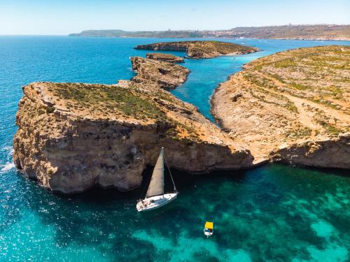 a sailboat in a cove in the ocean at Hyatt Regency Malta in St Julian's