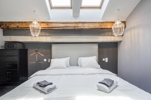 ein Schlafzimmer mit einem Bett mit zwei Handtüchern darauf in der Unterkunft Nador Boutique- Best Location, By BQA in Budapest