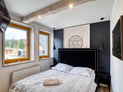 a bedroom with a large bed and a window at Apartament Śnieżny Deluxe Odkryj Zakopane in Kościelisko