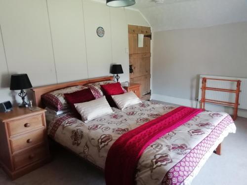 a bedroom with a bed and a wooden dresser with a bed sidx sidx sidx at Rectory Farm in Haverfordwest