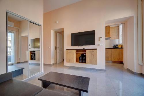 un salon avec une télévision à écran plat et une table dans l'établissement Immogroom- Sublime studio with terrace- close ShopsBar, à Cannes