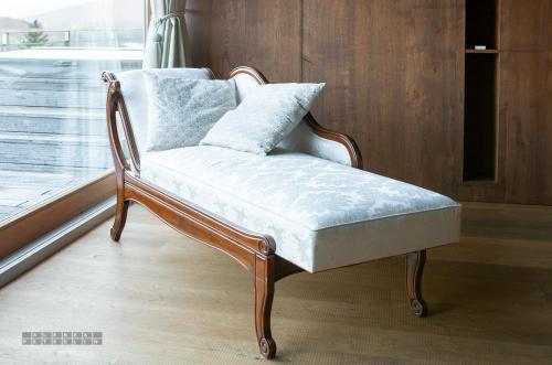 a wooden chair with a white seat in a room at Vinica Castle Boutique & Spa Hotel in Vinica