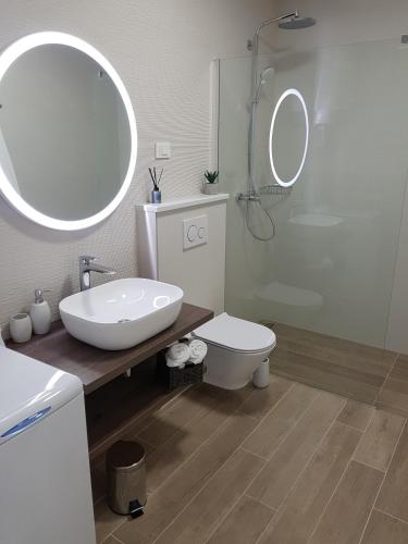 a bathroom with a sink and a toilet and a mirror at La Vista apartments in Mimice