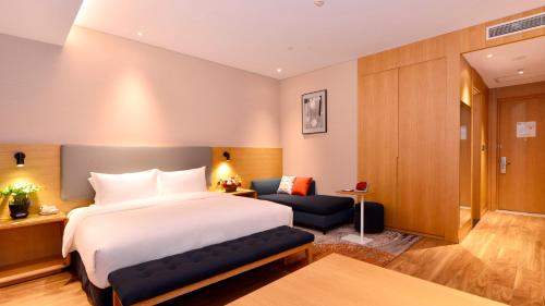 a hotel room with a bed and a chair at Holiday Inn Express Luanchuan by IHG in Luanchuan