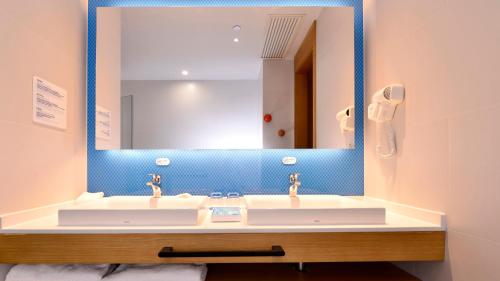 a bathroom with a sink and a mirror at Holiday Inn Express Luanchuan by IHG in Luanchuan
