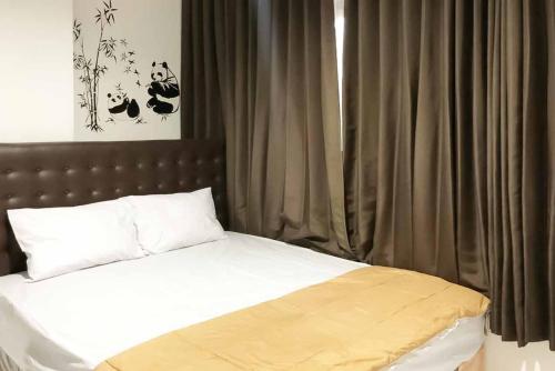 a bedroom with a bed with a brown headboard and curtains at SAS Guest House Mitra RedDoorz At Darmo Park 2 Surabaya in Surabaya