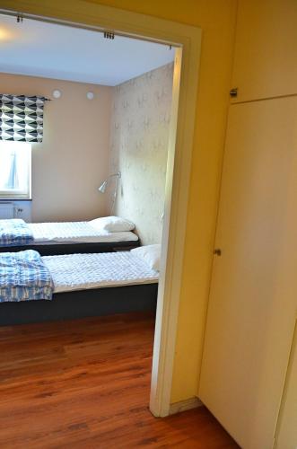 a bedroom with two beds and a door open at Lyckåhem Lågprishotell och Vandrarhem in Karlskrona
