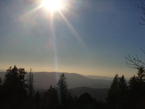 a sun is shining in the sky over the mountains at Pension Williams in Seebach