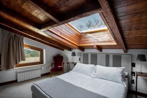 sypialnia z dużym łóżkiem i oknem dachowym w obiekcie La Locanda Del Pontefice - Luxury Country House w mieście Castel Gandolfo