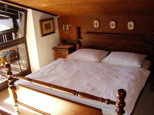 Schlafzimmer mit einem großen Bett mit einem Kopfteil aus Holz in der Unterkunft Appartementhaus Hochkönig 1- Schneeberg in Mühlbach am Hochkönig