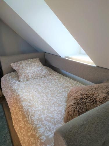 - un lit dans une chambre avec un oreiller et une fenêtre dans l'établissement La Nacelle, classée 3 étoiles, vue dégagée port et mer, au Tréport