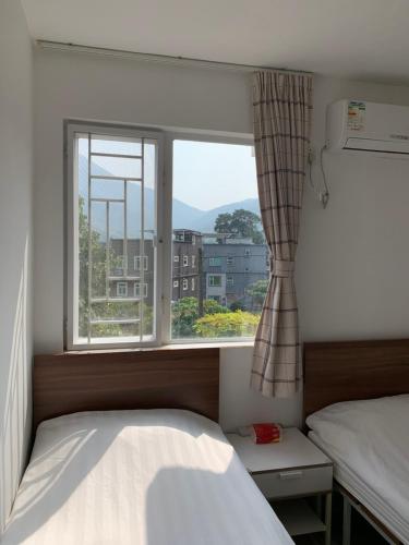 a bedroom with a bed and a large window at City Oasis Guesthouse in Hong Kong