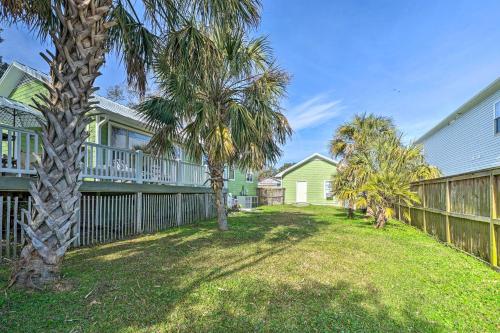 a yard with palm trees and a fence at Coastal Hideaway about half Mi to Beach and Boardwalk! in Carolina Beach