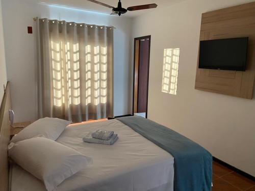 a bedroom with a bed with a flat screen tv at Hotel Confort in Mafra