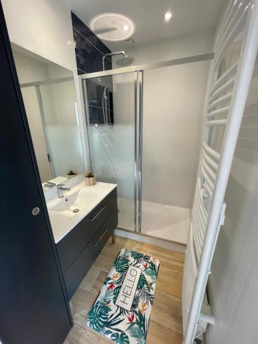 une salle de bain avec une douche, un lavabo et une baignoire dans l'établissement Les terrasses de l'océan A11, à Mimizan