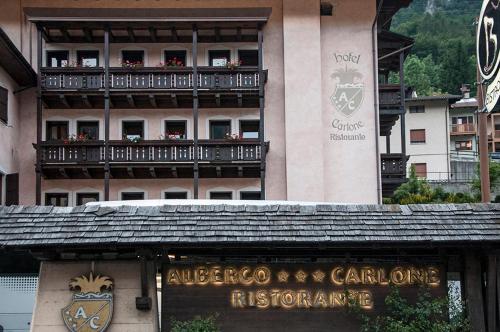 a building with a balcony in front of a restaurant at Hotel Carlone in Breguzzo