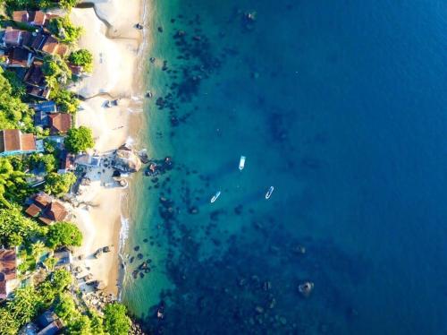 an aerial view of a beach with boats in the water at Pousada Convés - Ilha Grande in Praia de Araçatiba