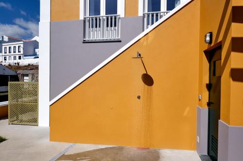 a yellow and white wall with a stairway at Mid-Atlantic Boutique Hostel in Angra do Heroísmo