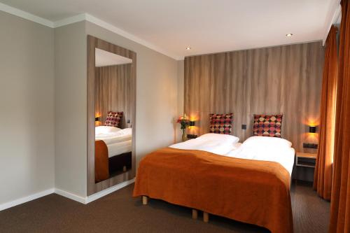 a hotel room with two beds and a mirror at Hotel Botterweck in Valkenburg
