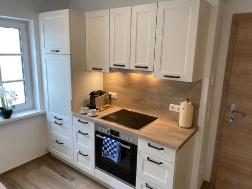 a kitchen with white cabinets and a sink at Im Kurpark in Bad Ischl