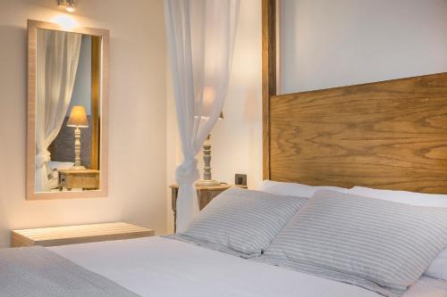 a bedroom with a white bed and a mirror at ASTRA Village Resort in Svoronata