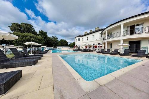 a swimming pool in front of a building at Mudeford Beach Lodge in Mudeford