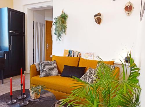 - un canapé jaune dans un salon orné de plantes dans l'établissement By Gwen - le Jaurès, à Arles