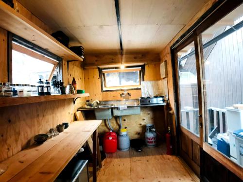 a small kitchen with a sink and a wooden table at Guesthouse Yadocurly in Onomichi