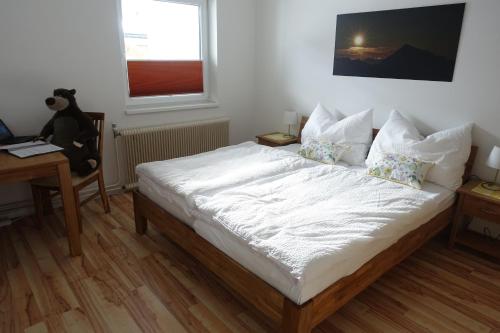 a bedroom with a bed and a desk and a window at Bungalow Baloo Ferienhaus in Sankt Johann in Tirol