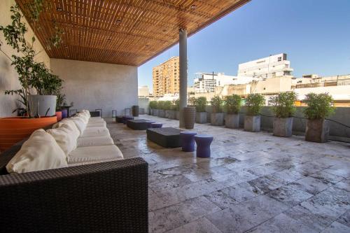un patio avec des canapés et des plantes dans un bâtiment dans l'établissement Premium Studio in heart of Palermo Soho -T107-, à Buenos Aires