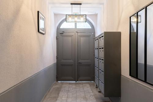 a hallway with a gray door in a room at Résidence Le Marly in Annemasse