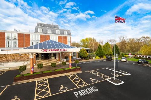 a parking lot in front of a building with a flag at Crowne Plaza Stratford-upon-Avon, an IHG Hotel in Stratford-upon-Avon