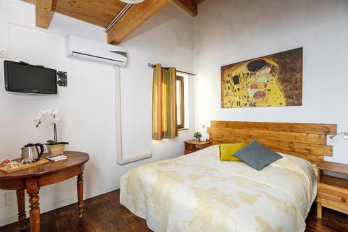 una camera da letto con un letto, un tavolo e una TV di B&B La Corte San Francesco a Bari