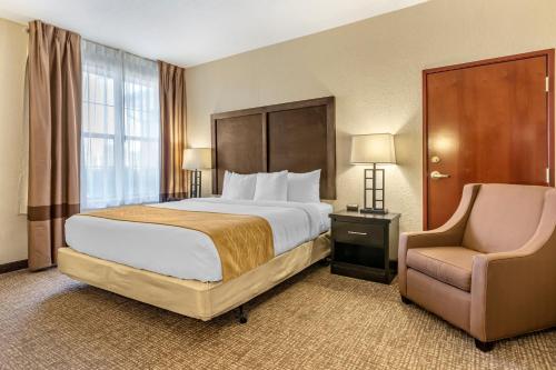 um quarto de hotel com uma cama e uma cadeira em Comfort Inn & Suites Allen Park - Dearborn em Allen Park