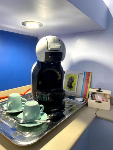 a coffee maker sitting on a shelf with two cups at Ambramarina B&B in Nettuno