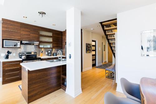 a kitchen with wooden cabinets and a dining room at Les Lofts St Jean in Quebec City