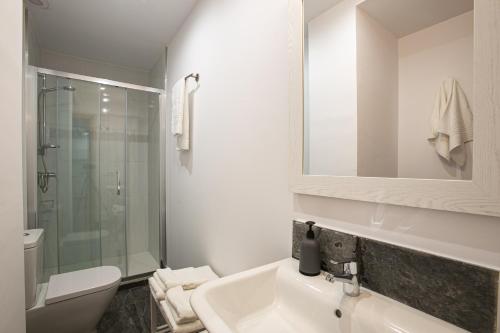 a bathroom with a sink and a toilet and a mirror at Can Prat Solei in Ripoll