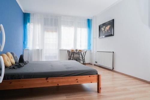 Un dormitorio con una cama con paredes azules y una mesa. en The Pearl of Esztergom, en Esztergom