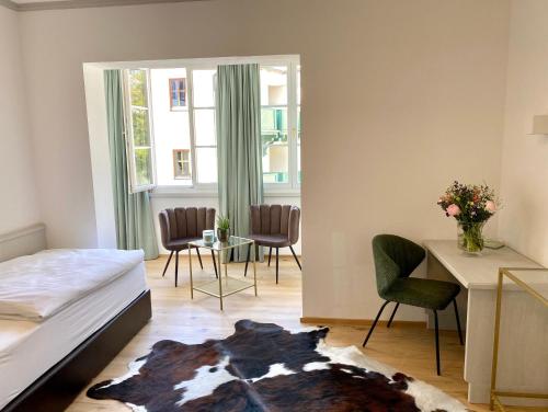 a bedroom with a bed and a table and chairs at Boutiquehotel Hubertushof in Bad Ischl