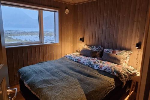 a bedroom with a bed with a view of the ocean at Magic views and walking distance to best beaches in Leknes